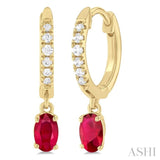 5x3 MM Oval Cut Ruby and 1/8 ctw Petite Round Cut Diamond Precious Fashion Huggies in 10K Yellow Gold